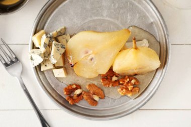 Şarap Beyaz ahşap masa üzerinde peynir ve tatlı armut ile plaka komposto