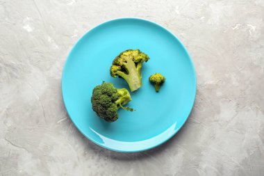 Gri arka plan üzerinde brokoli ile şık plaka