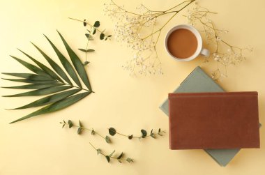 Kitaplar ile kompozisyon, fincan kahve ve tropikal renk arka plan üzerinde bırakır.