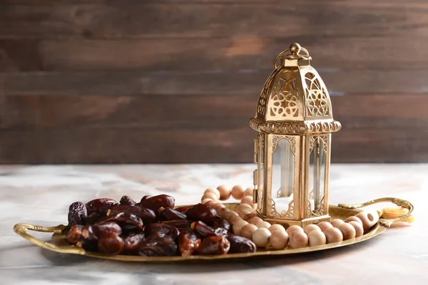 带祈祷珠和托盘上干燥日期的穆斯林灯笼 — 图库照片