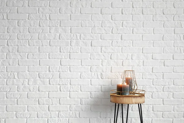 Égő Gyertyák Fehér Tégla Fal Közelében Fából Készült Asztal — Stock Fotó