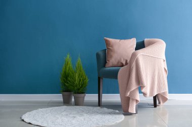 Rahat koltuk ve houseplants renk duvarının yakınında