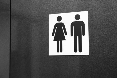 Koyu arka plan üzerinde erkek ve kadın figürleriyle tuvalet işareti