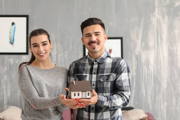 Пара держащих фигуру дома. Концепция страхования собственности
