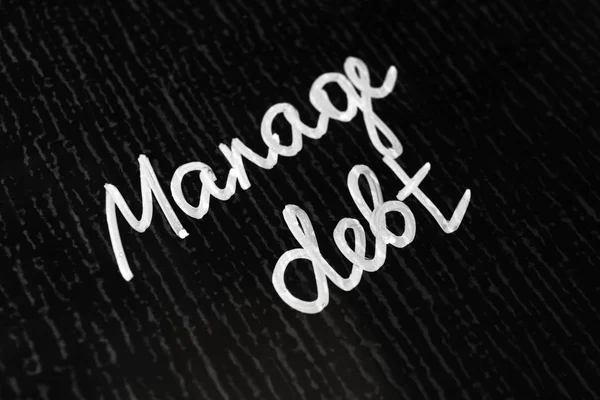 Text MANAGE DEBT on dark background