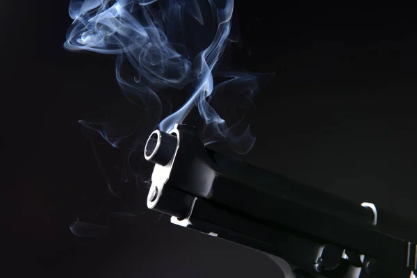 Smoking gun on dark background