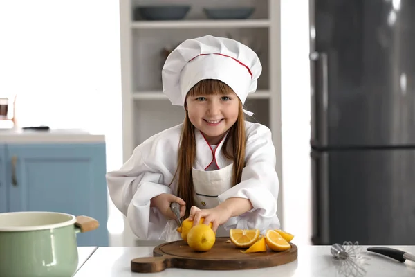 Cute little girl dressed as chef playing at home