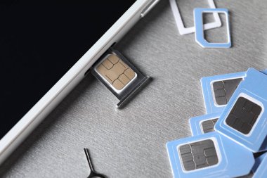Cep telefonu gri arka planda, closeup SIM kartlarla