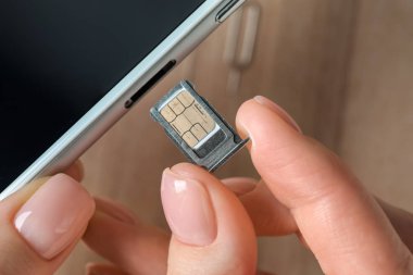Kadın hareket eden telefon, closeup SIM kartý takma