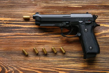 Tabanca ve mermileri ahşap arka plan üzerinde