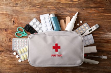 First aid kit on wooden background clipart