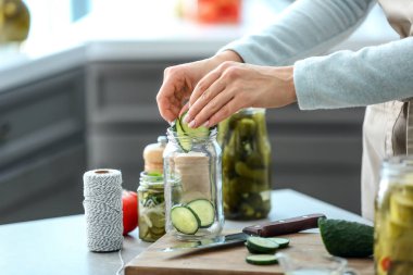 Kadın taze salatalık fermantasyon için mutfakta hazırlanıyor.