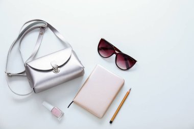Çanta ve beyaz arka plan üstünde defter ile kadın güneş gözlüğü
