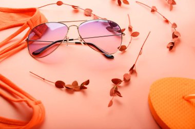 Güneş gözlüğü ve mercan arka plan üzerinde beachwear