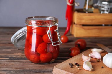 Ahşap masa üzerinde lezzetli fermente domates kavanoz