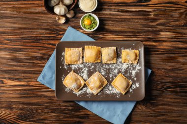 Ahşap masa üstünde pişmemiş mantı ile plaka