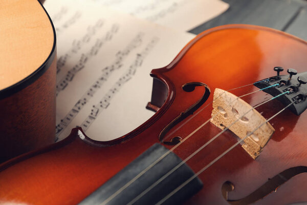 Скрипка и ноты на столе, крупный план
