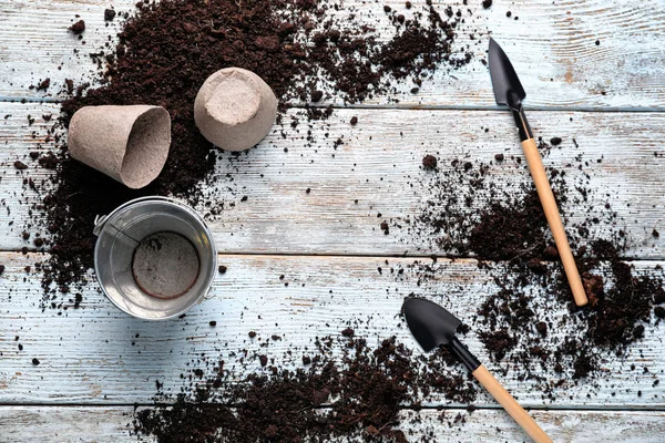 Toprak ve ahşap arka plan üzerinde Bahçe aletleri ile kompozisyon