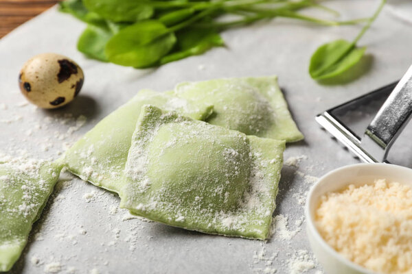 Uncooked ravioli with cheese on parchment, closeup