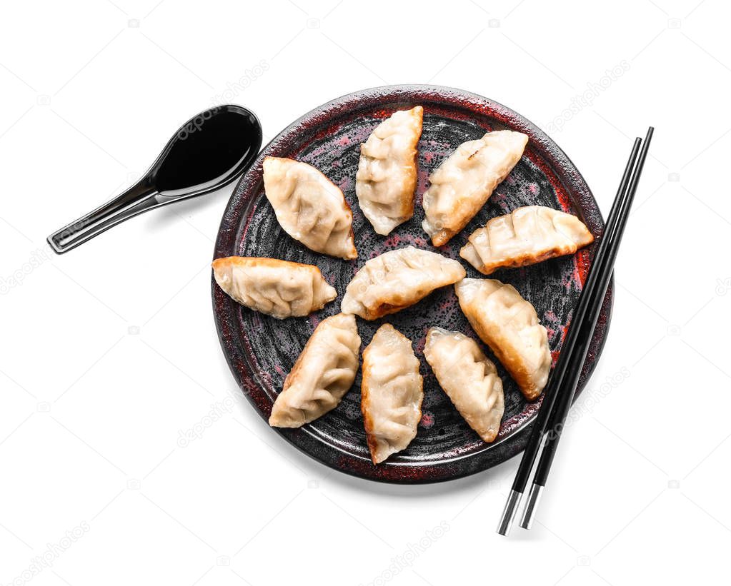 Plate with tasty Japanese gyoza on white background