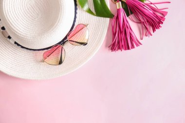 Kadın aksesuar ve tropikal yaprak renk arka plan üzerinde şık güneş gözlüğü