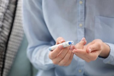 Diyabetik kadın mazgal kalem, closeup kullanarak kan örneği alarak