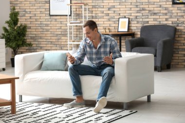 Evde cep telefonu olan yakışıklı bir genç.