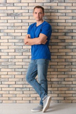 Yakışıklı genç adamın yanında tuğla duvar