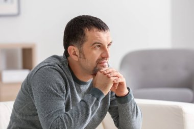 Evde koltukta oturan olgun adam