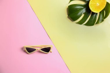 Turuncu ve tropikal yaprak renk arka plan üzerinde şık kadın güneş gözlüğü