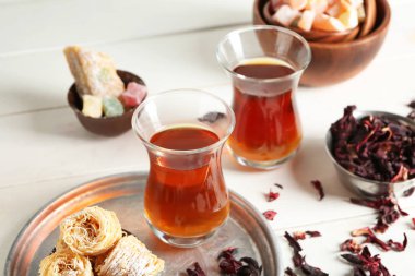Beyaz masa Doğu sweets ile geleneksel bardaklarda Türk çayı