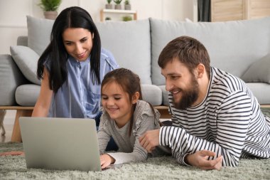 Mutlu aile evde dizüstü bilgisayar kullanıyor.