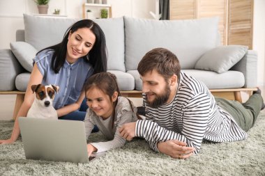 Mutlu aile evde dizüstü bilgisayar kullanıyor.