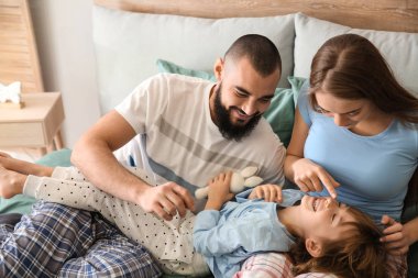 Evde yatakta mutlu aile