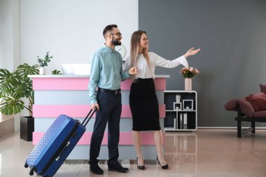 Genç adam ve otelin resepsiyon masası hostes