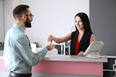 Otelin Resepsiyon masasında odasından alan anahtar genç adam