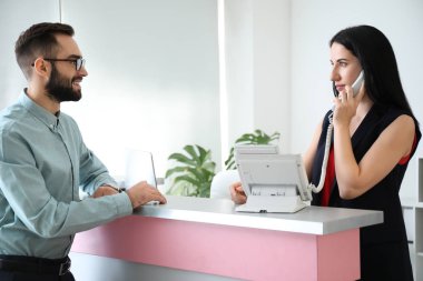 Oteldeki resepsiyondaki genç adam.