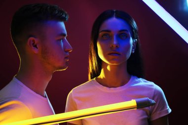 Neon lambaları koyu arka plan üzerinde genç çift portresi