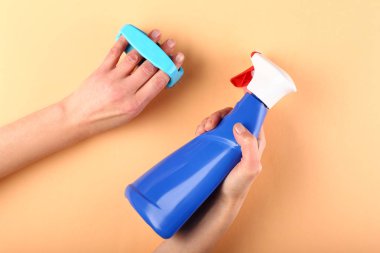 Fırça ve deterjan renk arka plan üzerinde kadın hademe elinde