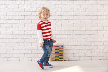 Abaküs beyaz duvara yakın olan şirin küçük çocuk portresi