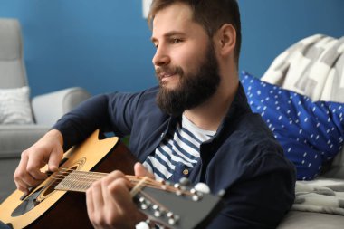 Sakallı adam evde gitar çalmak