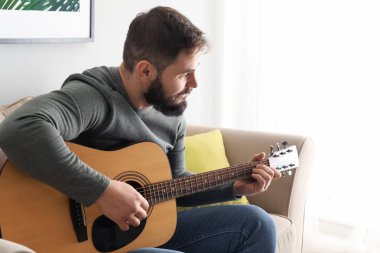 Sakallı adam evde gitar çalmak