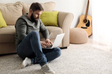 sakallı adam üstünde laptop evde çalışma