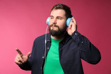 Sakallı adam renk arka plan üzerinde müzik dinlemek