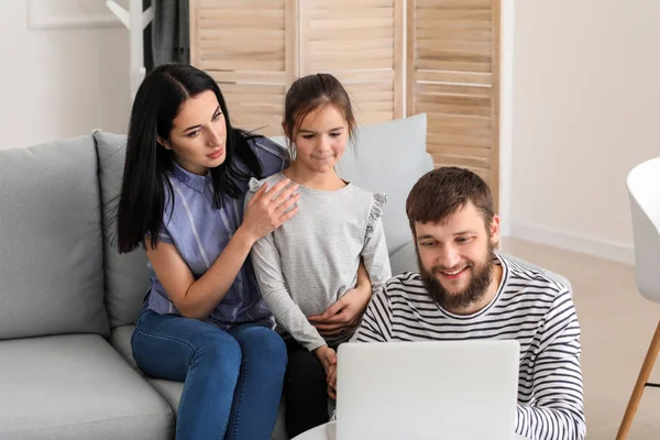 Happy family using laptop at home