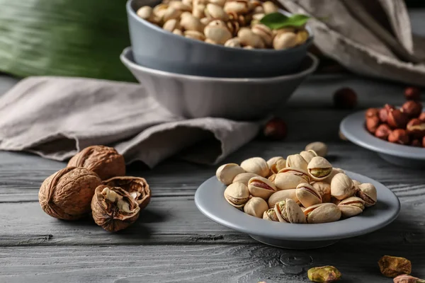 Plate Tasty Pistachio Nuts Walnuts Wooden Table — Stock Photo, Image