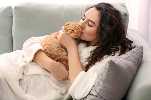 年轻女子亲吻可爱有趣的猫在家里 — 图库照片