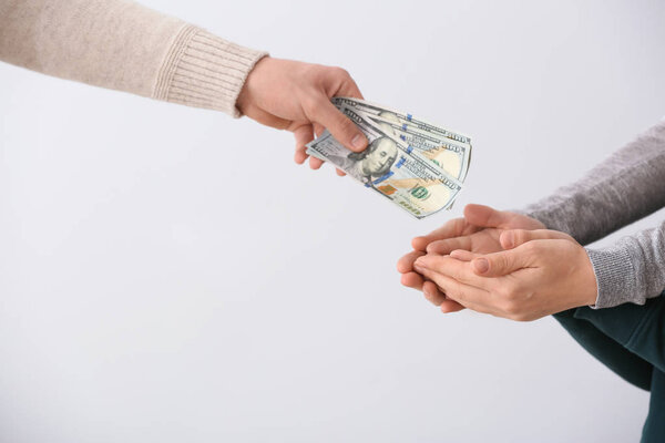 Мужчина, выплачивающий алименты своей бывшей семье на светлом фоне
