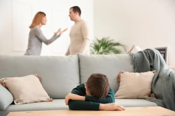 悲伤的小男孩和他在家里争吵的父母 — 图库照片