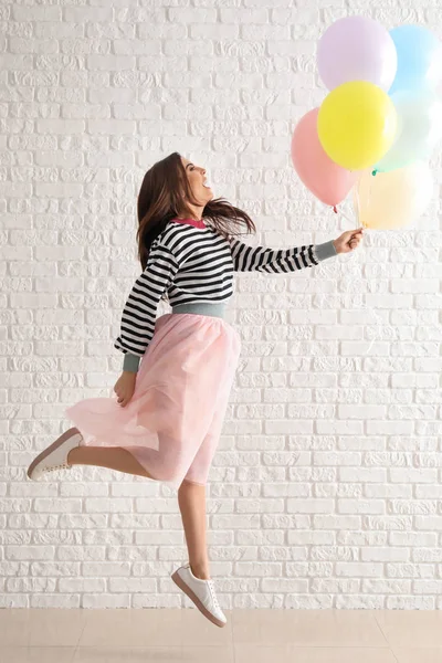 Mujer Joven Saltando Con Globos Contra Pared Ladrillo Blanco —  Fotos de Stock